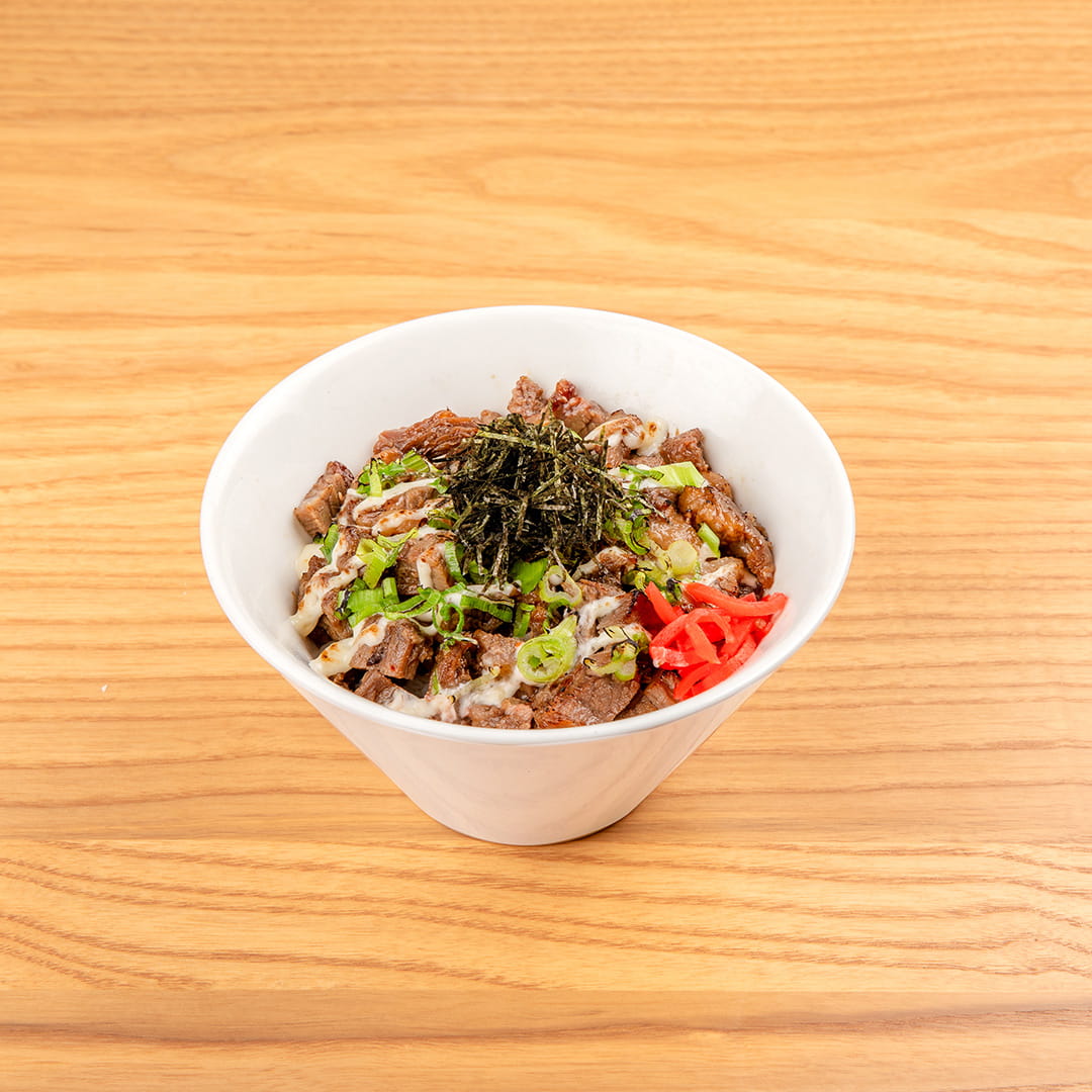 A serving of beef donburi, featuring chopped beef over rice, garnished with KINTON original sauce, honey, mayo, shredded nori, red ginger, scallions, served at Kinton Ramen