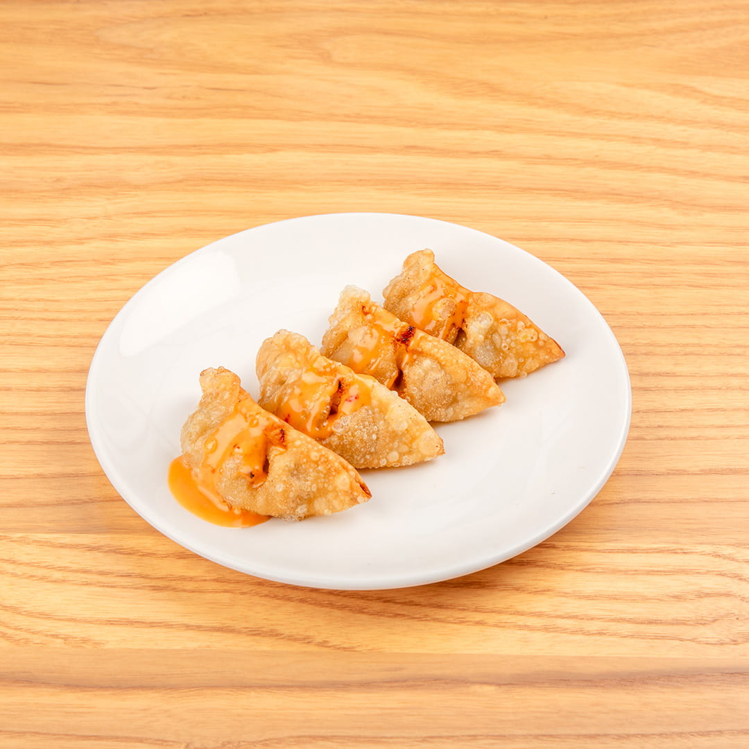 Plate of crispy pork gyoza, featuring golden-brown dumplings filled with savory pork, covered with a sauce at Kinton Ramen.