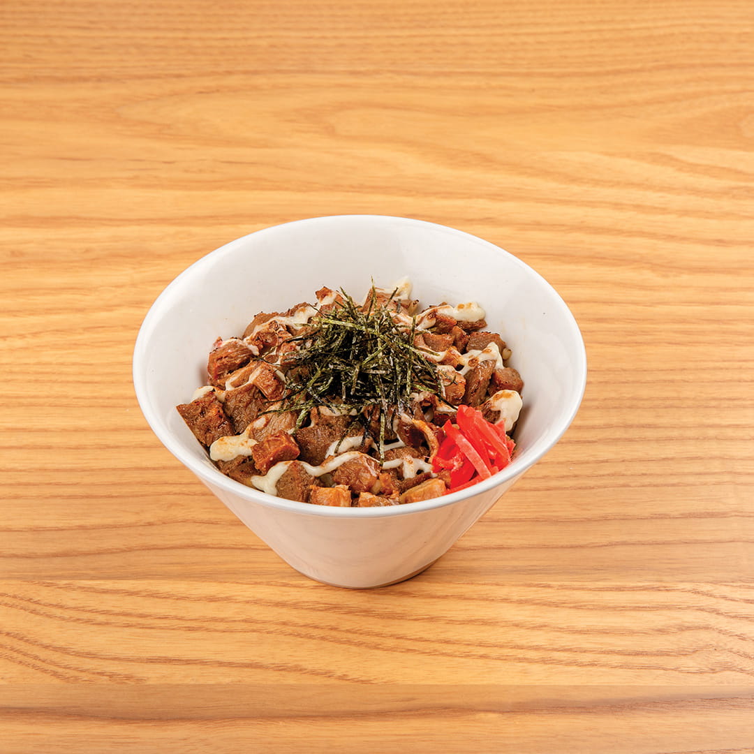 A serving of beef donburi, featuring chopped pork shoulder over rice, garnished with KINTON original sauce, honey, mayo, shredded nori, red ginger, scallions, served at Kinton Ramen.