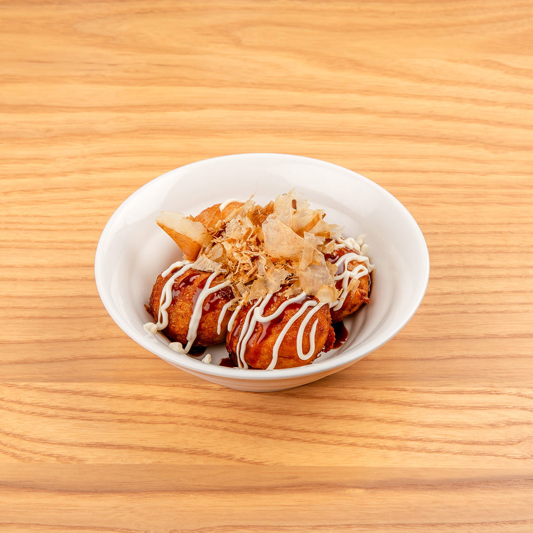 Delicious takoyaki balls drizzled with savory sauce and topped with bonito flakes, served as an appetizer at Kinton Ramen.