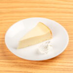 A slice of yuzu cheesecake, showcasing a creamy texture, served as a dessert option at Kinton Ramen.