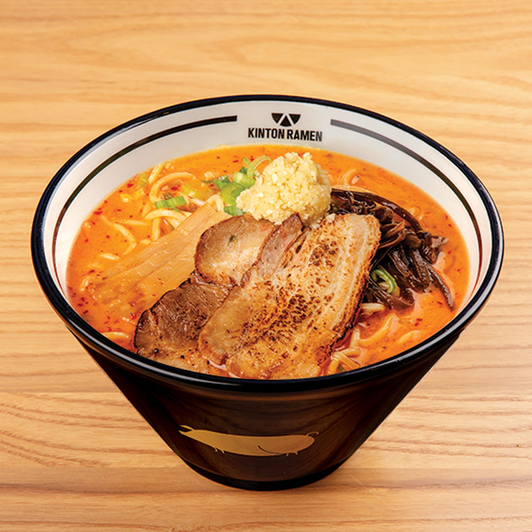 A bowl of Pork Spicy Garlic ramen, featuring tender pork slices, a rich garlic-infused broth, and fresh toppings, served at Kinton Ramen.